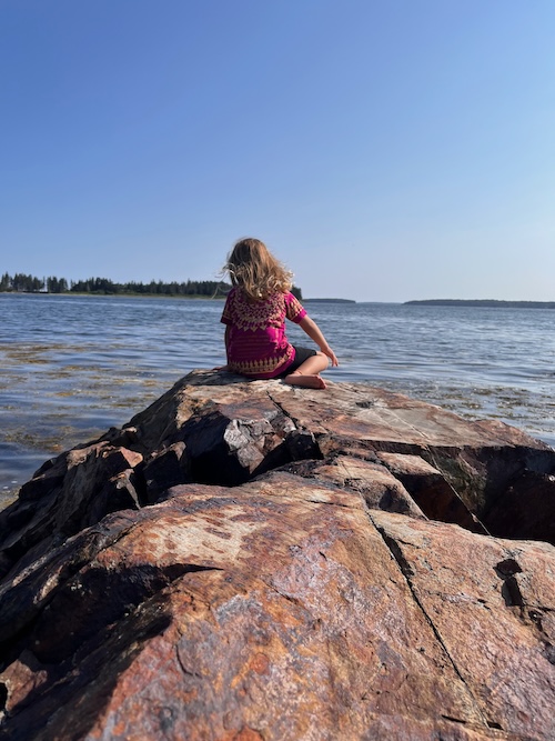 Anna playing on a rocky beach in Maine